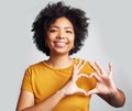 Portrait, woman and smile with heart hands in studio, white background and care of kindness, emoji and icon. Happy young Royalty Free Stock Photo