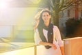 Portrait, woman and smile in nature for travel, autumn and lens flare with sunshine. Happy, trip and holiday home in