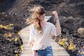 Portrait of a woman smiling with long blonde hair all over her faceGirl walking on windy wooden path with hair on her face Royalty Free Stock Photo