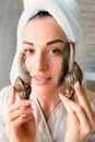 Portrait of woman with snails on her face