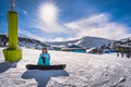 Portrait of a woman snowboarder sitting on snow and looking at camera, Andorra Royalty Free Stock Photo