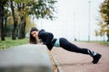 Portrait of woman in sportswear, doing fitness push-ups exercise at fall park, outdoor. Royalty Free Stock Photo