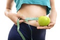 Fit girl measuring her waist and holding green apple Royalty Free Stock Photo