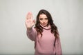 Portrait of a serious young woman standing with outstretched hand showing stop gesture isolated over white background Royalty Free Stock Photo