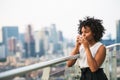 A portrait of a woman standing on a terrace, drinking coffee. Royalty Free Stock Photo