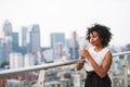 A portrait of a woman standing on a terrace, holding a cup of coffee. Royalty Free Stock Photo