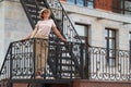 Portrait of woman standing on urban fire escape Royalty Free Stock Photo