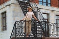 Portrait of woman standing on urban fire escape Royalty Free Stock Photo