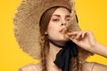 Portrait woman in straw hat on yellow background cropped view of summer dress model pigtails romance