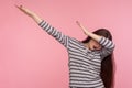 Portrait of woman in striped sweatshirt standing in dab dance pose, feeling famous and successful on internet Royalty Free Stock Photo