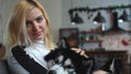 Portrait of woman stroking a husky and looking at the camera on the background of a Christmas-decorated kitchen. Dogs