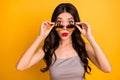 Portrait of woman in stupor putting her sunglass spectacles down to look at you with lips pouted pomaded isolated vivid Royalty Free Stock Photo