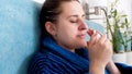 Portrait of young woman suffering from rhinitis using nasal spray Royalty Free Stock Photo
