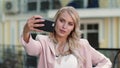 Portrait woman taking selfie on phone outdoor. Woman making selfie at street