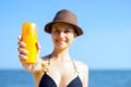 Portrait of woman taking skincare with sunscreen lotion at beach