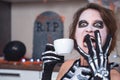 Portrait of woman with themed makeup and in skeleton costume, who holds a cup and screams in pain, horror or anger Royalty Free Stock Photo