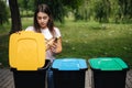 Portrait woman throwing empty plastic water bottle in recycling bin. Tree recycling bins outdoors Royalty Free Stock Photo