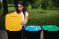 Portrait woman throwing empty plastic water bottle in recycling bin. Tree recycling bins outdoors Royalty Free Stock Photo