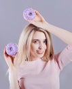 Portrait of a woman in trendy sunglasses with violet donuts in hands