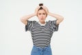 Portrait of woman in trouble, holding hands on head and panicking, looking worried, isolated over white background Royalty Free Stock Photo