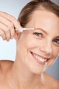 Portrait of woman, tweezers and eyebrow hair removal for clean cosmetics, face and beauty on studio background in Royalty Free Stock Photo