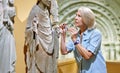 Portrait of woman visitor near sculpture in the historical museum.