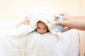 portrait of woman waking up girl with alarm clock at early morning