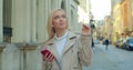Portrait of woman walking in the city center with Smartphone and Earphones. Chatting in social networks with his friends