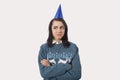 Portrait of woman wearing Christmas jumper and party hat against gray background