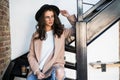 Portrait of woman wearing a coat. Beautiful young woman in coat descending steps in modern interior. Woman in casual style coat on Royalty Free Stock Photo