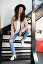 Portrait of woman wearing a coat. Beautiful young woman in coat descending steps in modern interior. Woman in casual style coat on Royalty Free Stock Photo