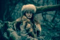 Portrait of a woman wearing fur hat and fox fur pelt on her shoulders.Shot in forest surroundings. Royalty Free Stock Photo
