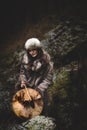 Portrait of a woman wearing fur hat and fox fur pelt on her shoulders.Playing shamanic drum.Shot in forest surroundings. Royalty Free Stock Photo