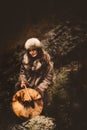 Portrait of a woman wearing fur hat and fox fur pelt on her shoulders.Playing shamanic drum.Shot in forest surroundings. Royalty Free Stock Photo