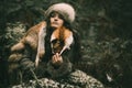 Portrait of a woman wearing fur hat and fox fur pelt on her shoulders.Shot in forest surroundings. Royalty Free Stock Photo