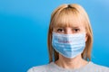 Portrait of woman wearing medical mask with epidemic word at blue background. Protect your health. concept Royalty Free Stock Photo