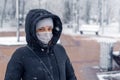 Portrait of a woman wearing a medical protective mask on her face in winter, Covid-19 coronavirus pandemic, virus protection