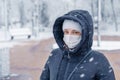 Portrait of a woman wearing a medical protective mask on her face in winter, Covid-19 coronavirus pandemic, virus protection