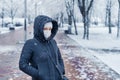 Portrait of a woman wearing a medical protective mask on her face in winter, Covid-19 coronavirus pandemic, virus protection