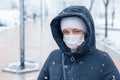 Portrait of a woman wearing a medical protective mask on her face in winter, Covid-19 coronavirus pandemic, virus protection