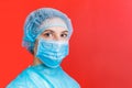 Portrait of a woman wearing medical uniform and mask at red background. concept. Protect your health concept with copy Royalty Free Stock Photo