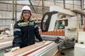 portrait woman wearing uniform and white hard hat working wood products at workshop manufacturing wooden. female carpenter worker Royalty Free Stock Photo