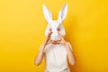 Portrait of woman wearing white T-shirt and paper rabbit mask yelling loud, proclaiming, announcing news or advertisement,