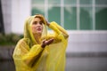 Women wearing yellow raincoat while raining in rainy season Royalty Free Stock Photo