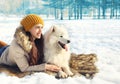 Portrait of woman and white Samoyed dog lying on the snow Royalty Free Stock Photo