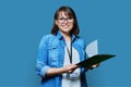 Portrait of woman worker with industrial center card clipboard, on blue background