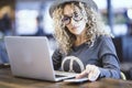 Portrait of woman working with computer in a cafe or airport gate station. Digital nomad and modern worker. Female people using Royalty Free Stock Photo