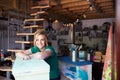 Portrait Of Woman In Workshop Upcycling And Working On Furniture With Sandpaper