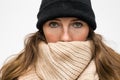 Portrait of woman wrapped in winter had and scarf, winter woolen wearing looking cold