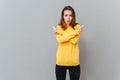 Portrait of a woman in yellow sweater pointing fingers away Royalty Free Stock Photo